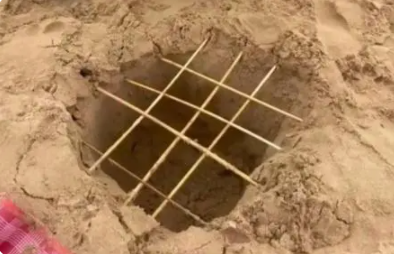 青島一母親曬孩子沙灘制竹簽陷阱照片，陷阱極其逼真，引網友爭議